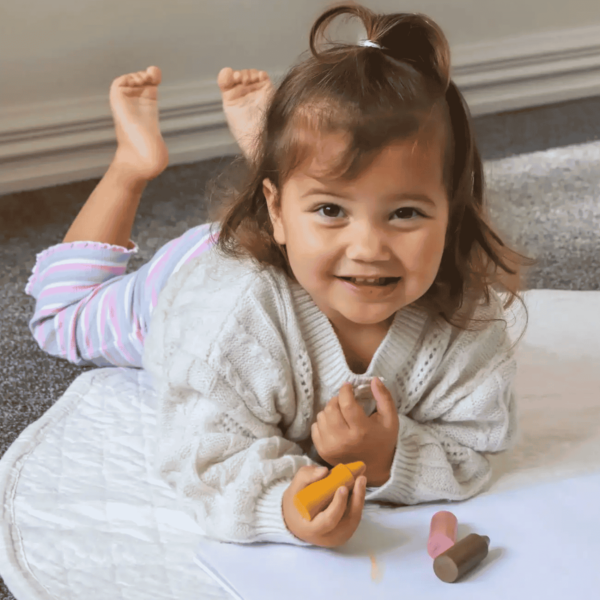 Child playing with colorful toys on a carpeted floor