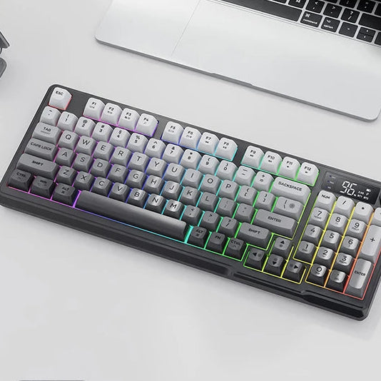 Wireless keyboard and mouse kit with RGB lighting on a white surface, featuring a laptop and smartphone in the background.