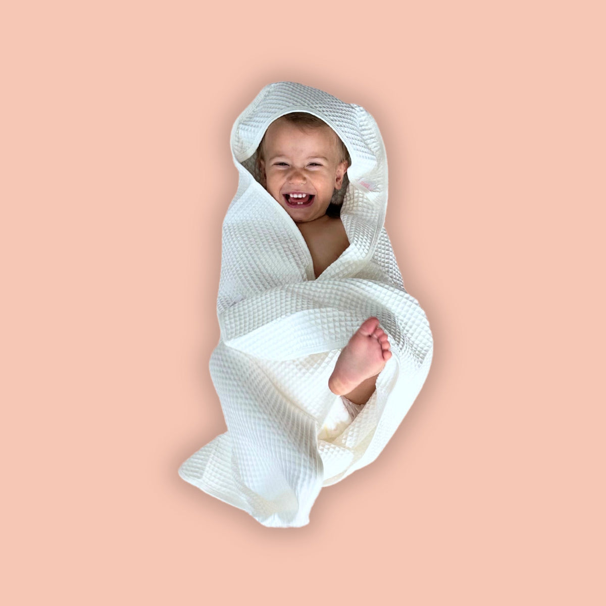Baby wrapped in a white blanket on a pink background