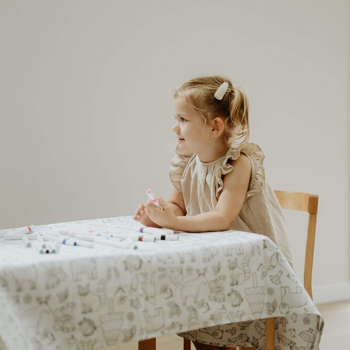 A girl enjoying colouring in at the table.