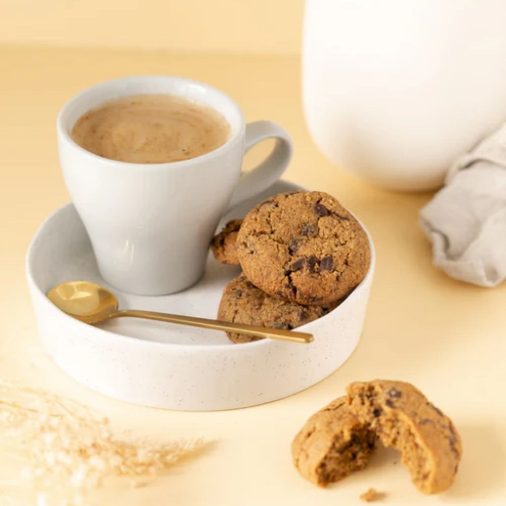 A breastfeeding mother enjoy her Milk Collective Lactation Cookies with her coffee.