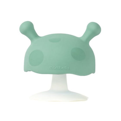 Green silicone teether with a white base on a white background, featuring the brand 'mombella'.