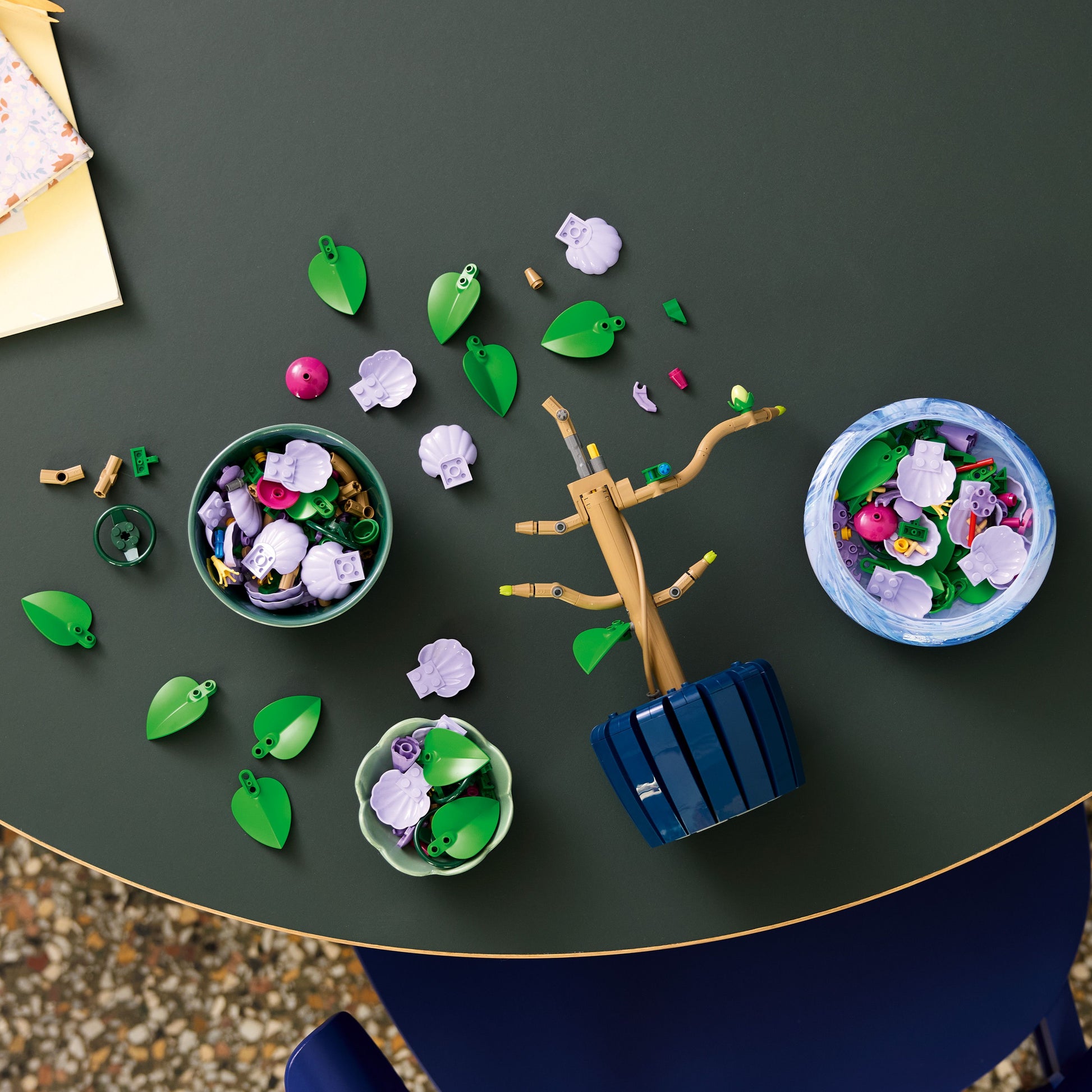  LEGO® Botanicals Hibiscus with various components on a dark surface