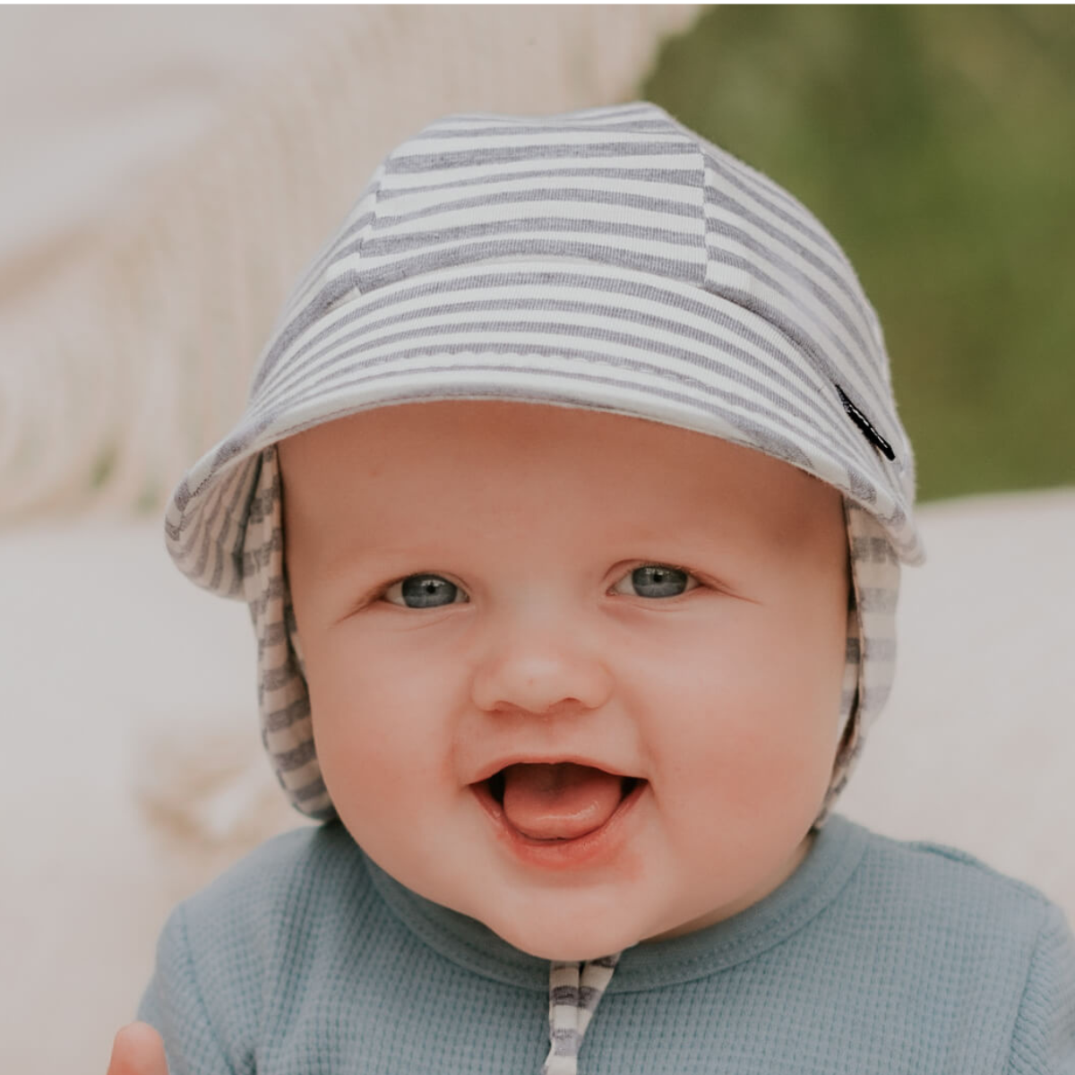 Baby wearing a striped hat with a blurred natural background