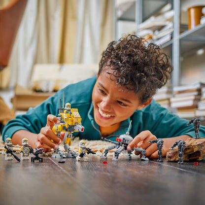 Child playing with toy Star Wars figures on the floor. 