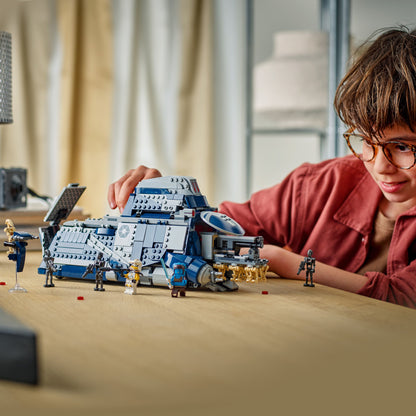 Child playing with a detailed model of a spaceship and figures on a table.
