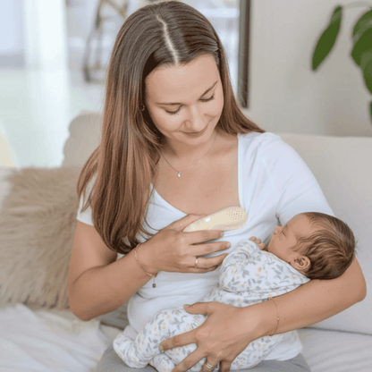 Beige electronic device suitable for breast massage to assist with breastfeeding with perforated design on a white background