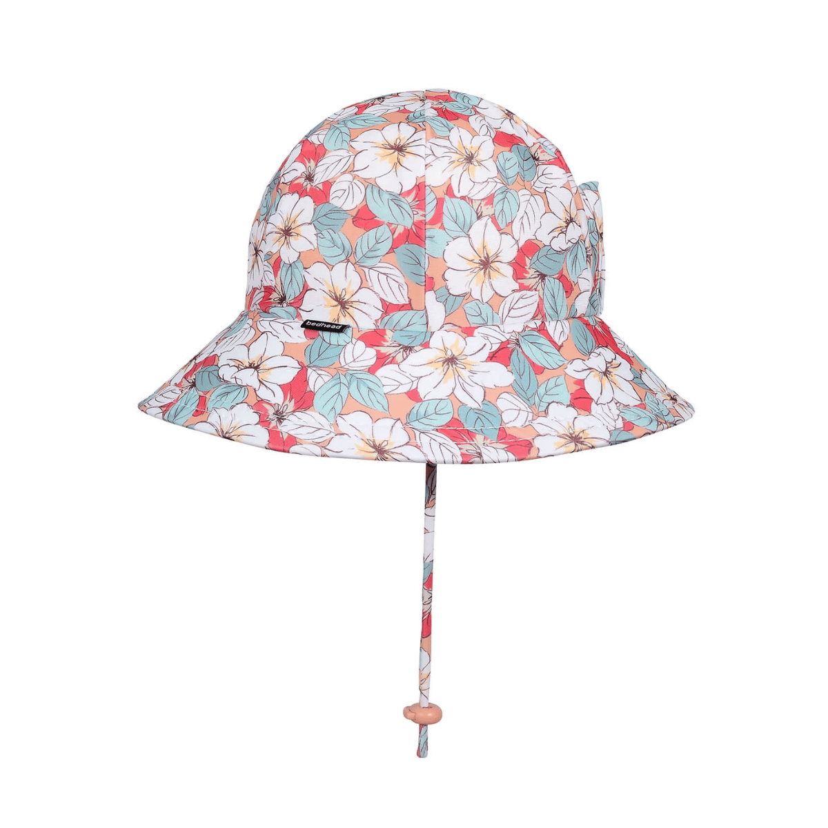 A floral bucket hat with a white, coral, and teal hibiscus flower pattern, featuring a matching chin strap with a wooden bead.