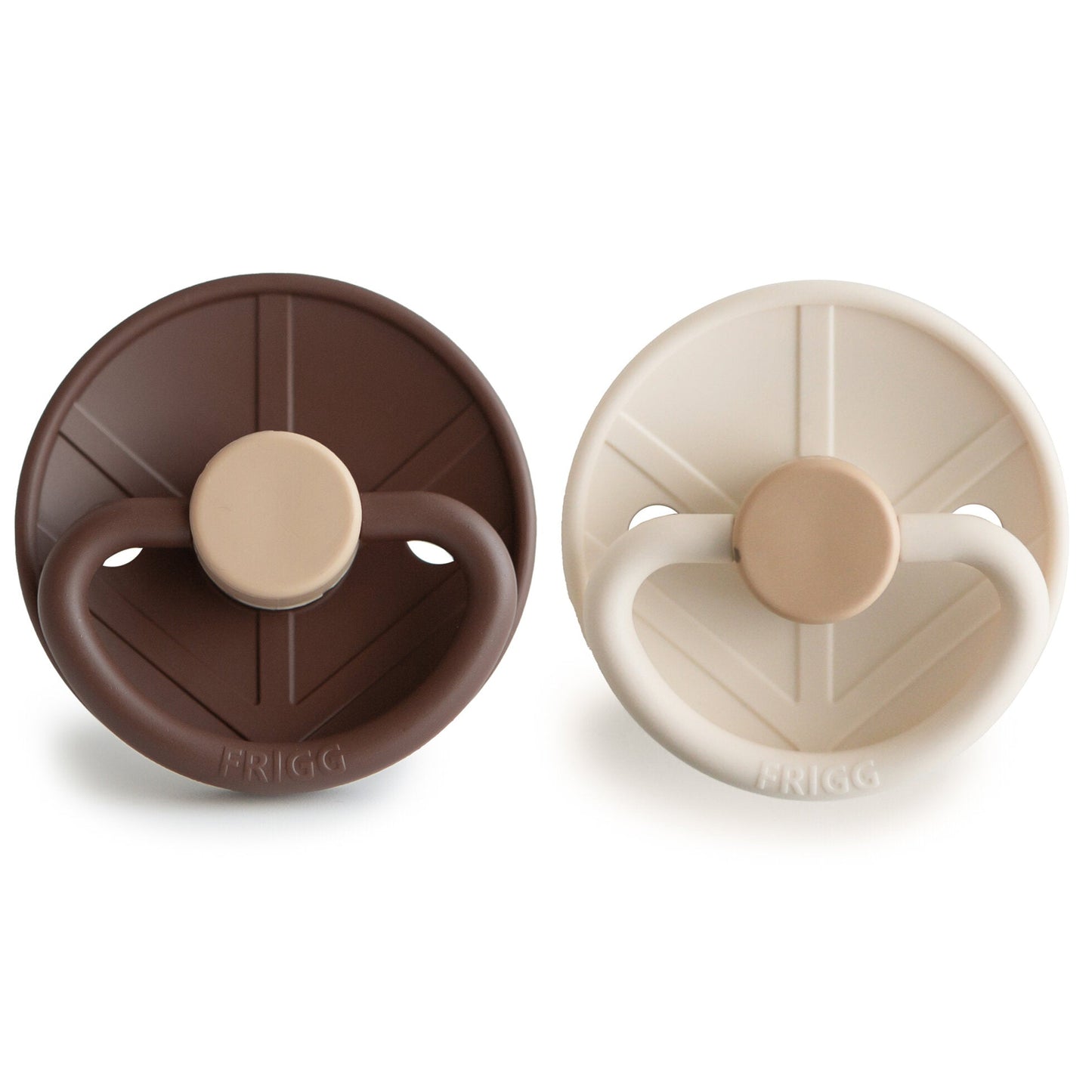 Two baby pacifiers, one brown and one beige, on a white background with 'FRIGG' branding, which is a Swedish Brand.