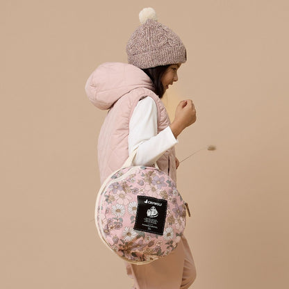A girl showing the size of the bag once it's folded up.
