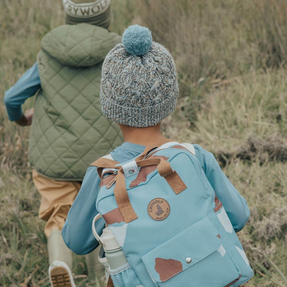 A boy showing the back of the blue speckled pom pom beanie by Crywolf.