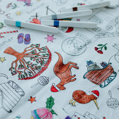 Coloring table cloth with Christmas-themed illustrations and coloring tools.