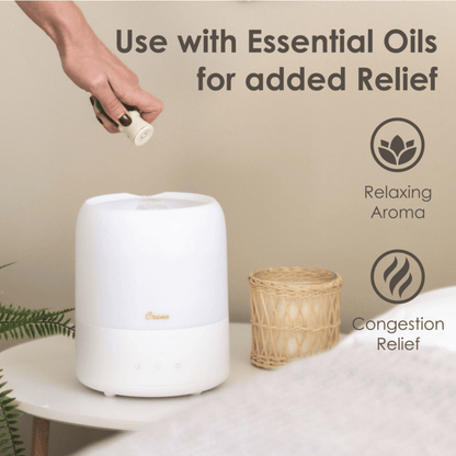 White diffuser on a table with a hand adding essential oil, text about uses, and icons.