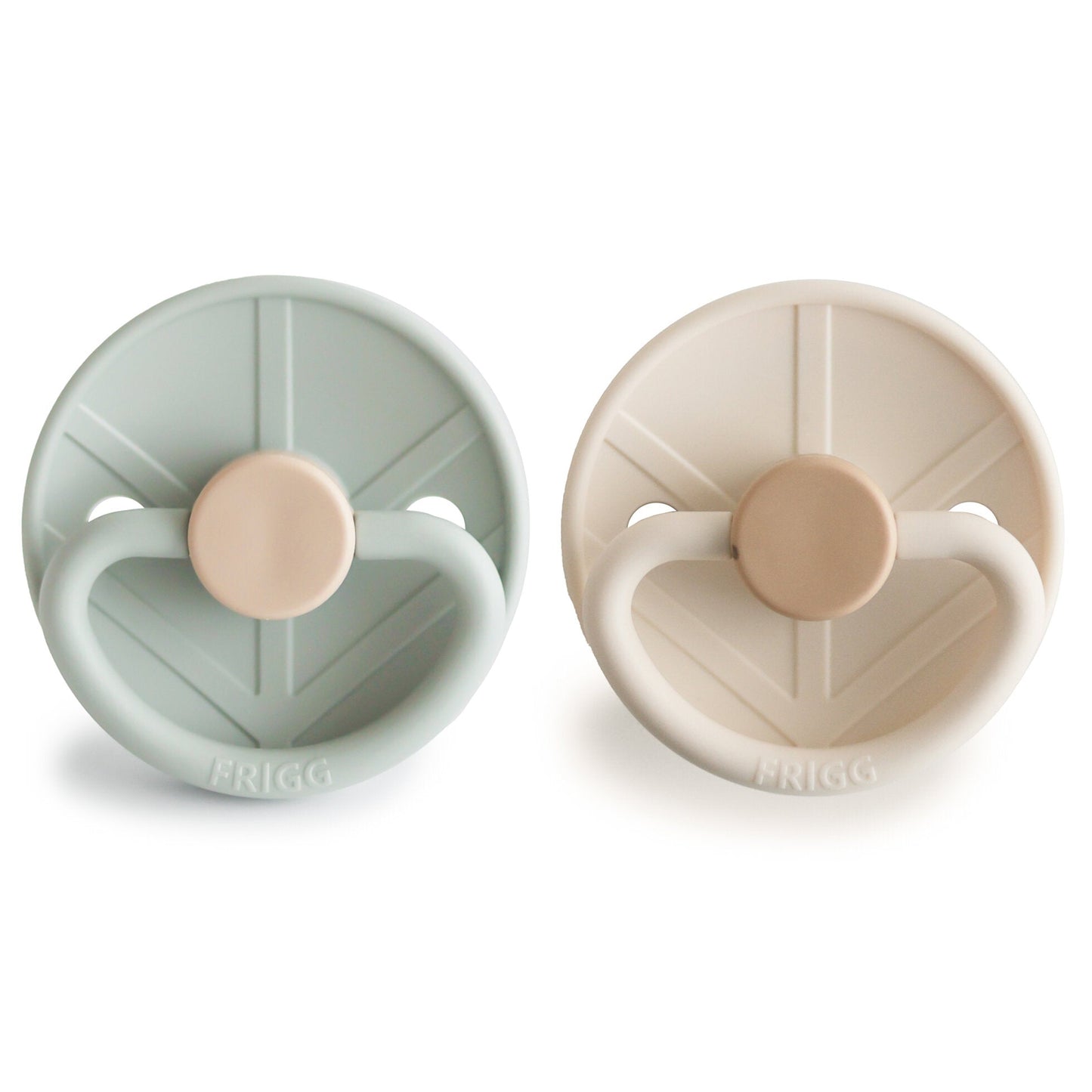Two pacifiers, one green and one beige, with 'Frigg' branding on a white background.
