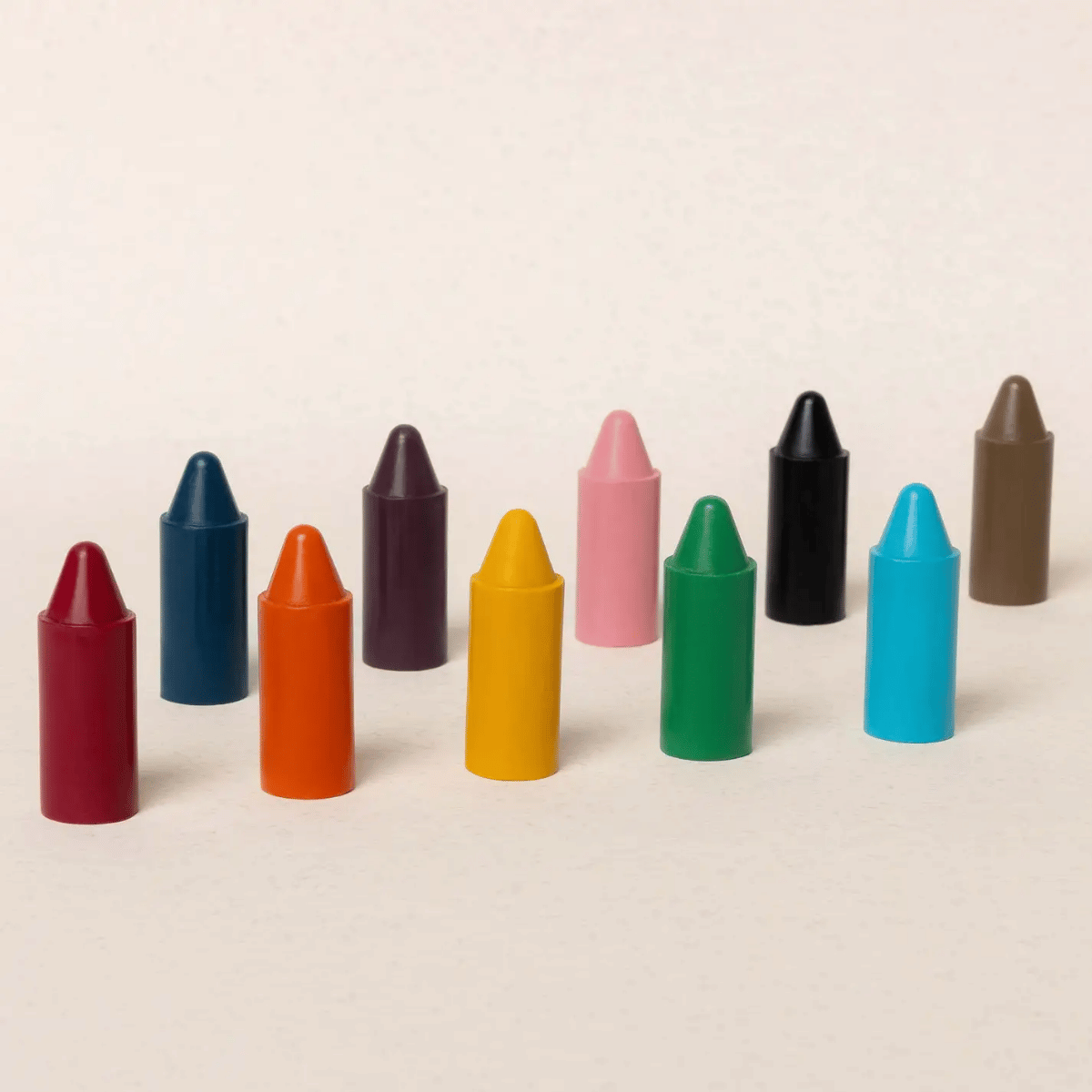 Row of colorful crayons on a beige background