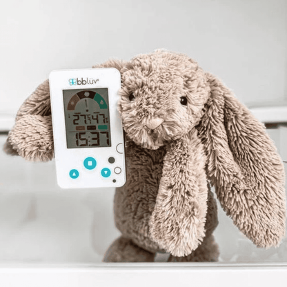Plush bunny toy with a digital thermometer on a white background