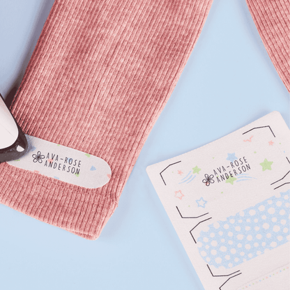 Pink ribbed socks with 'Ava-Rose Anderson' branding on a light blue background