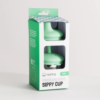 Green sippy cup in packaging with 'nestling' branding on a light gray background