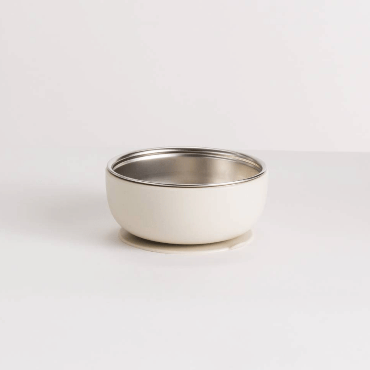 Small white bowl with a silver rim on a light gray background