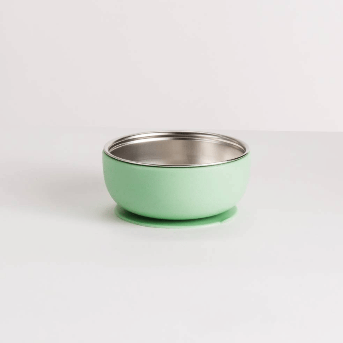 Green  bowl with silver stainless steel interior on a white background
