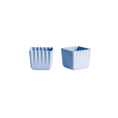 Two small square ribbed plastic cups in light blue, shown side by side on a plain white background.