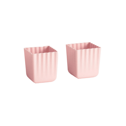 Two small pink square containers with a fluted or ribbed edge, shown on a plain white background.
