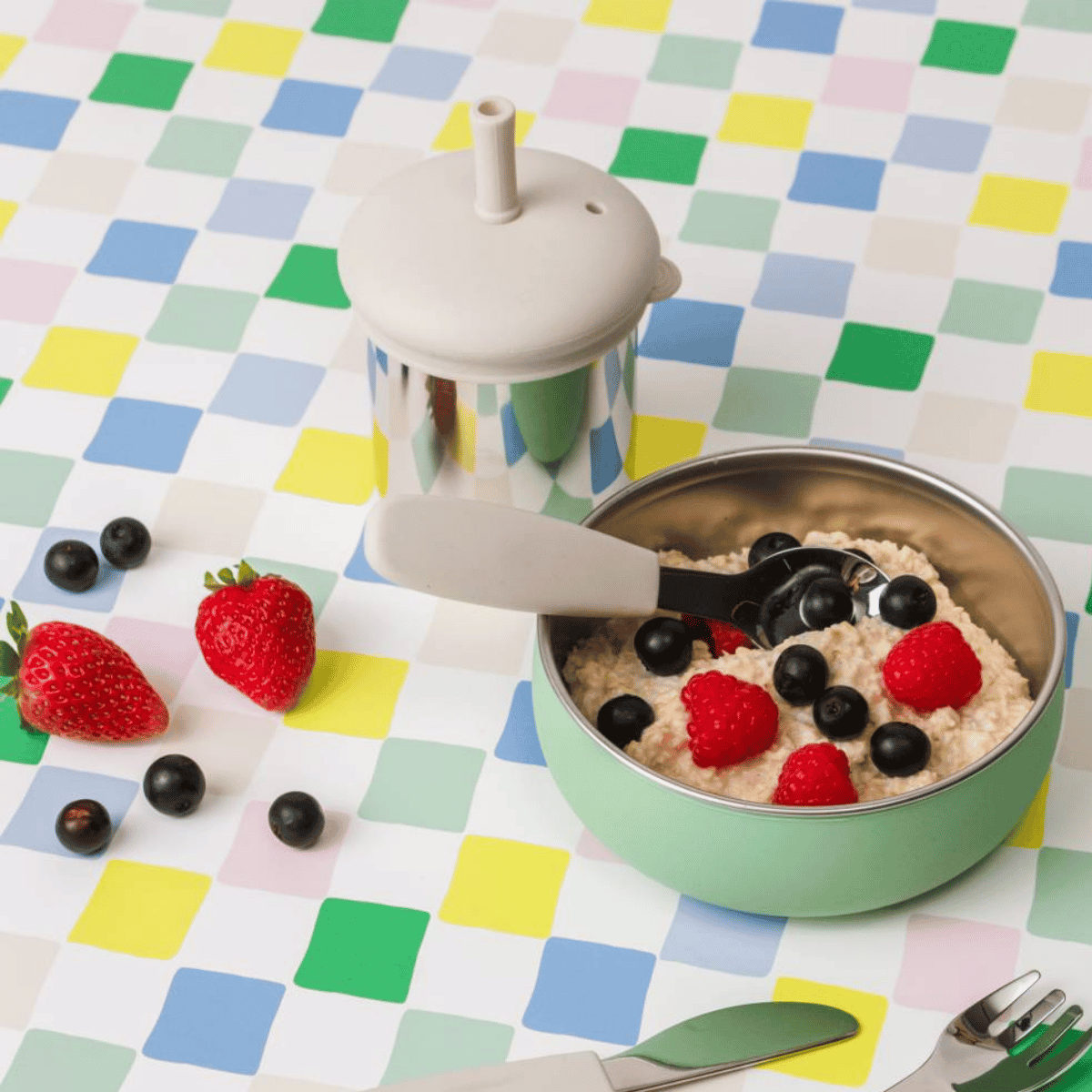 Bowl of oatmeal with berries on a colorful checkered tablecloth