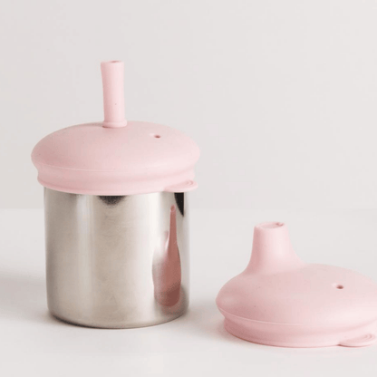 Pink lid on a stainless steel cup with another pink lid on a white background