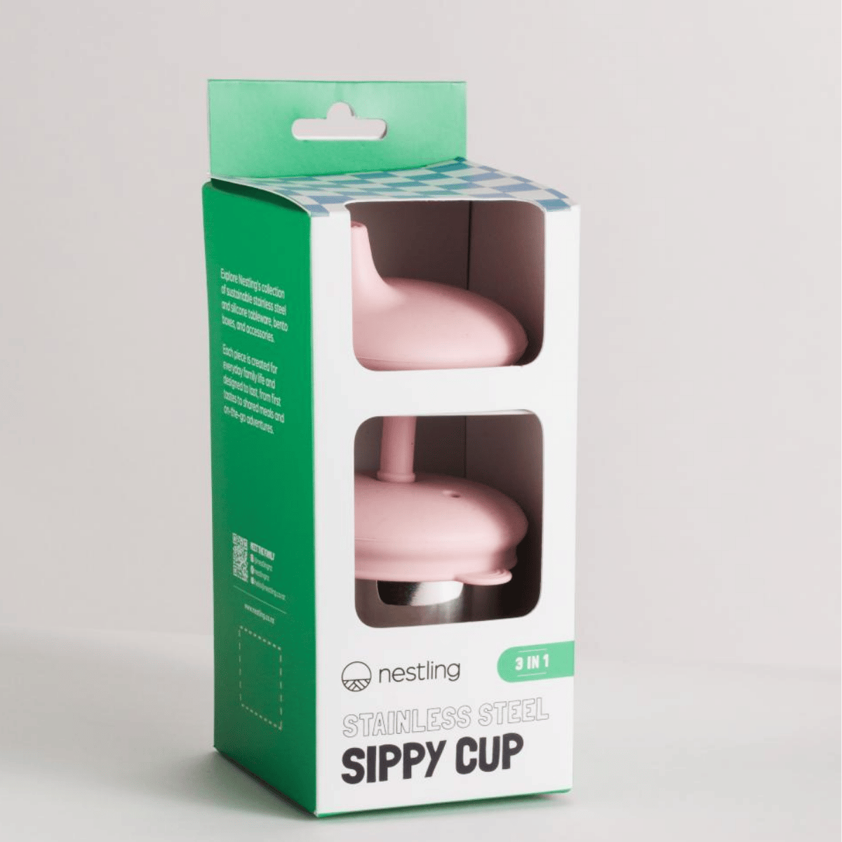Pink sippy cup in a green and white packaging box on a light gray background
