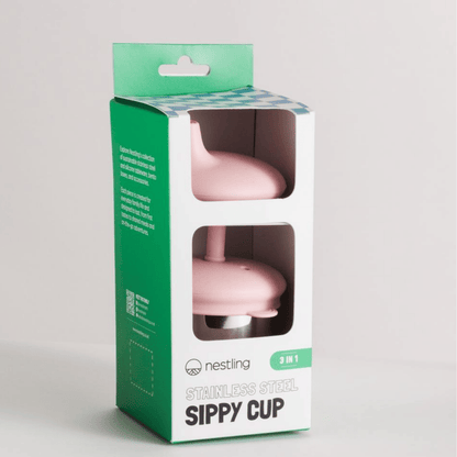 Pink sippy cup in a green and white packaging box on a light gray background