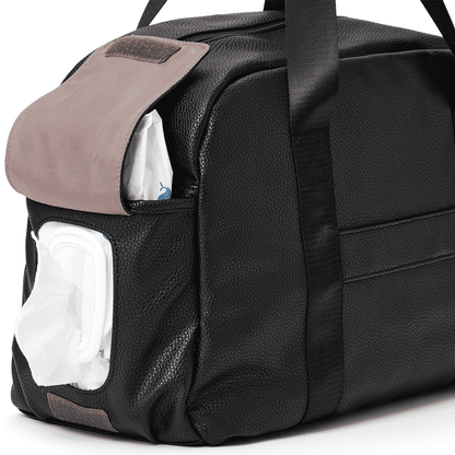 Black duffel bag with a pocket containing wet wipes on a white background