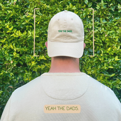 A dad wearing the 'yeah the dads' mum club hat.