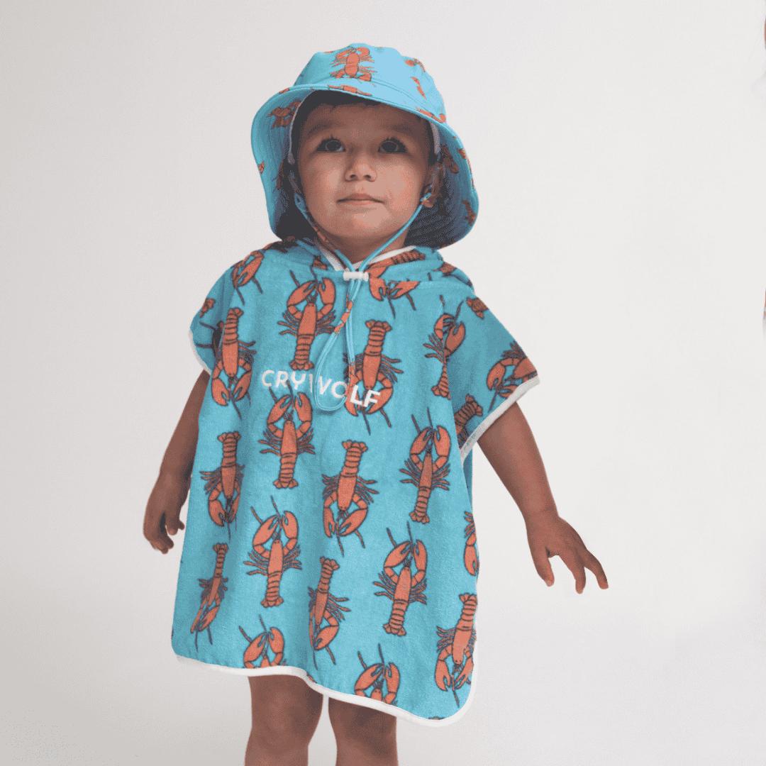 A boy wearing the baby hooded towel with lobsters on it.