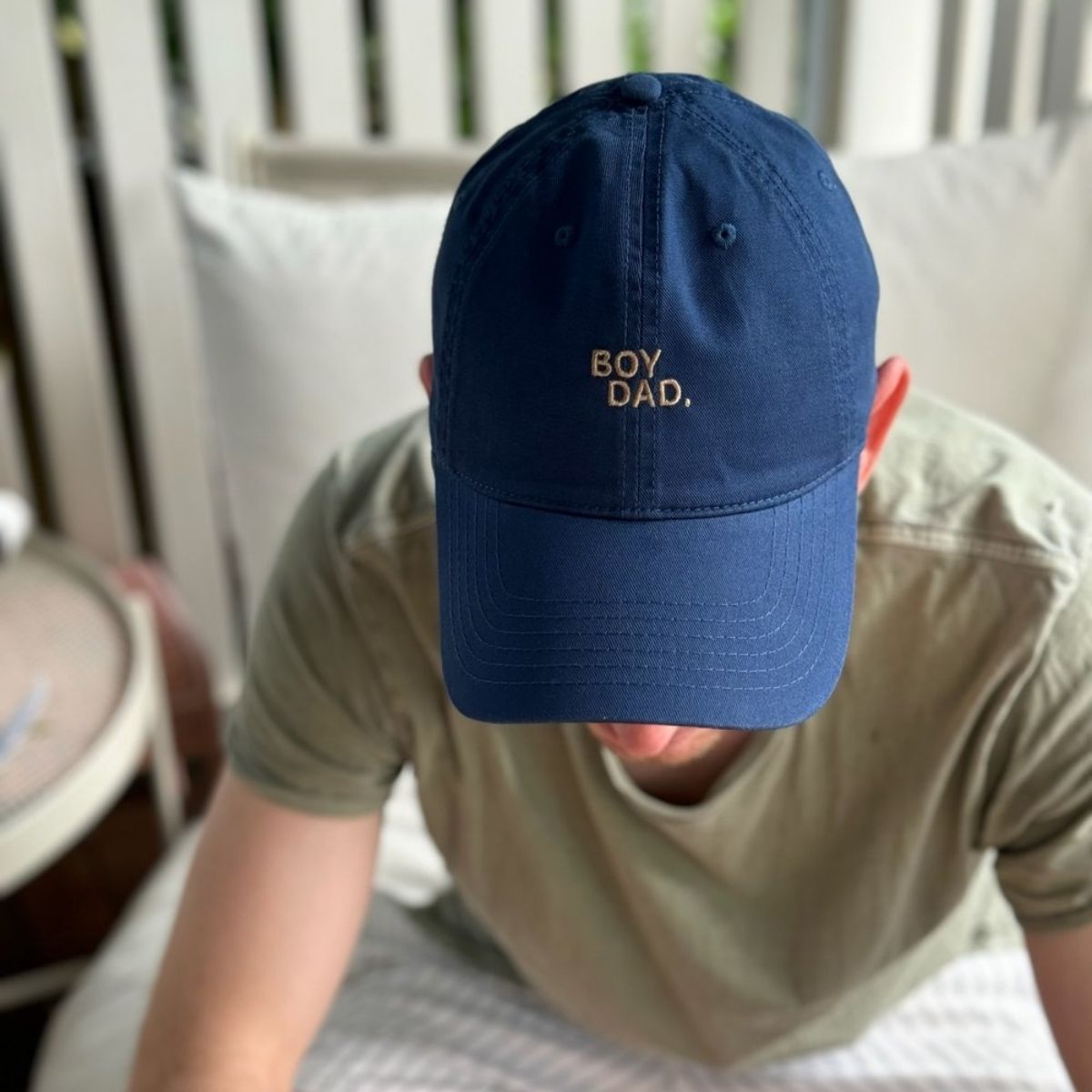 A dad showing what the boy dad hat looks like on.