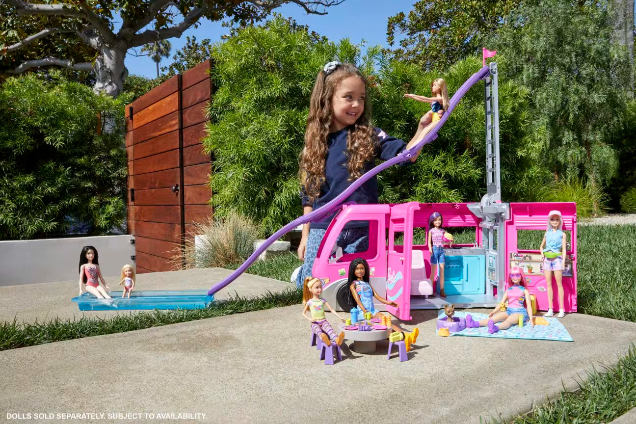 Child playing with a Barbie playset in an outdoor setting