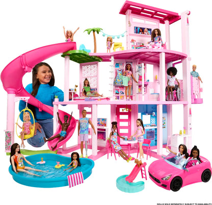 Barbie Dreamhouse with multiple dolls around it on a white background