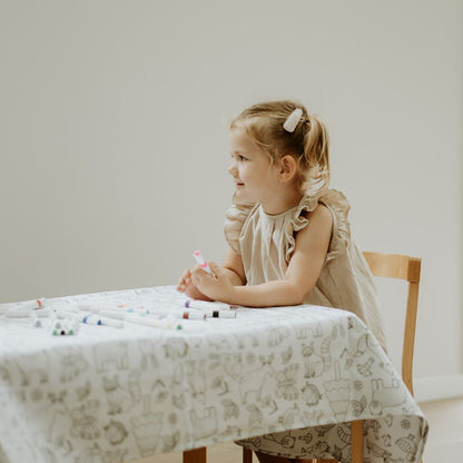 A girl enjoying colouring in at the table.