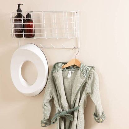 The Luma toilet seat hanging next to a Green robe in the bathroom.