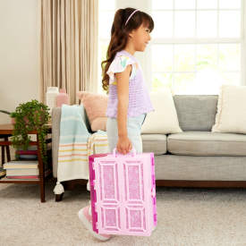 Child holding a pink suitcase in a living room