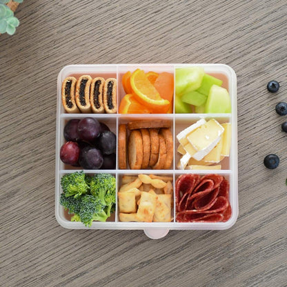 An example of some snacks like oranges, musli bards, cheese in the container.
