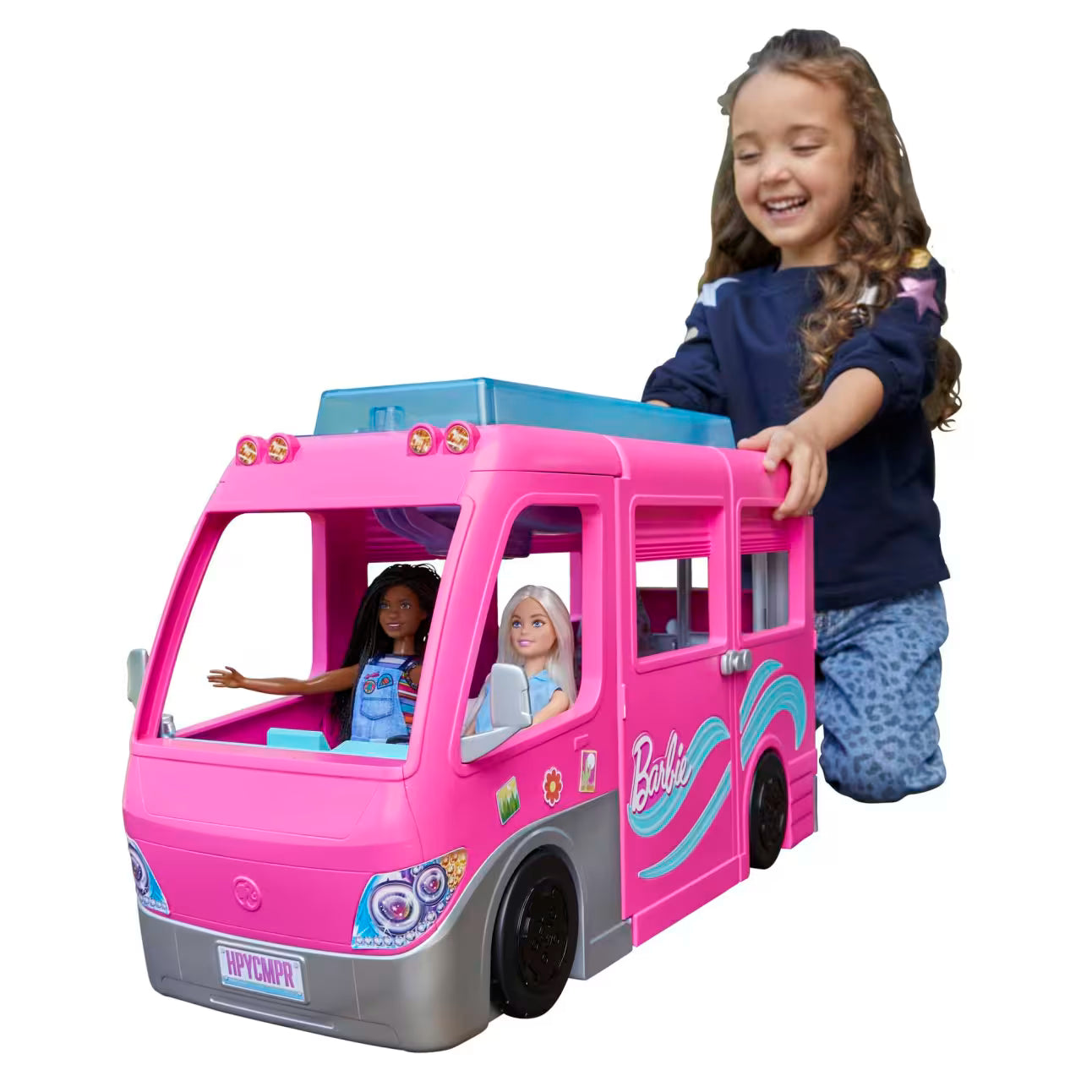 Child playing with a pink toy camper van featuring dolls inside on a white background